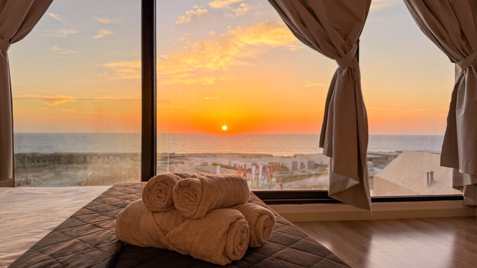Rolled towels on the bed at sunset