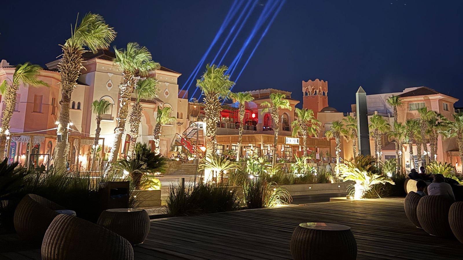 Palm trees and restaurants lit up at night