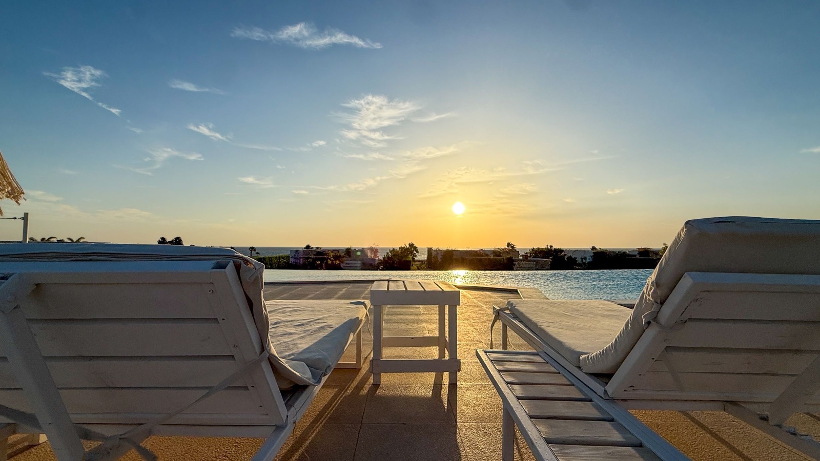 Sunbeds by the pool at sunset