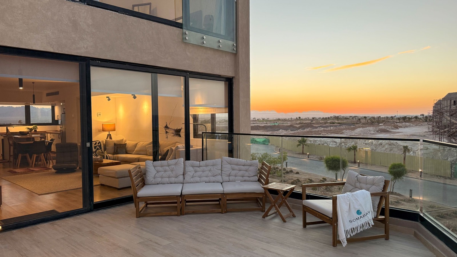 Terrace lit up at sunset, with the living room glowing behind